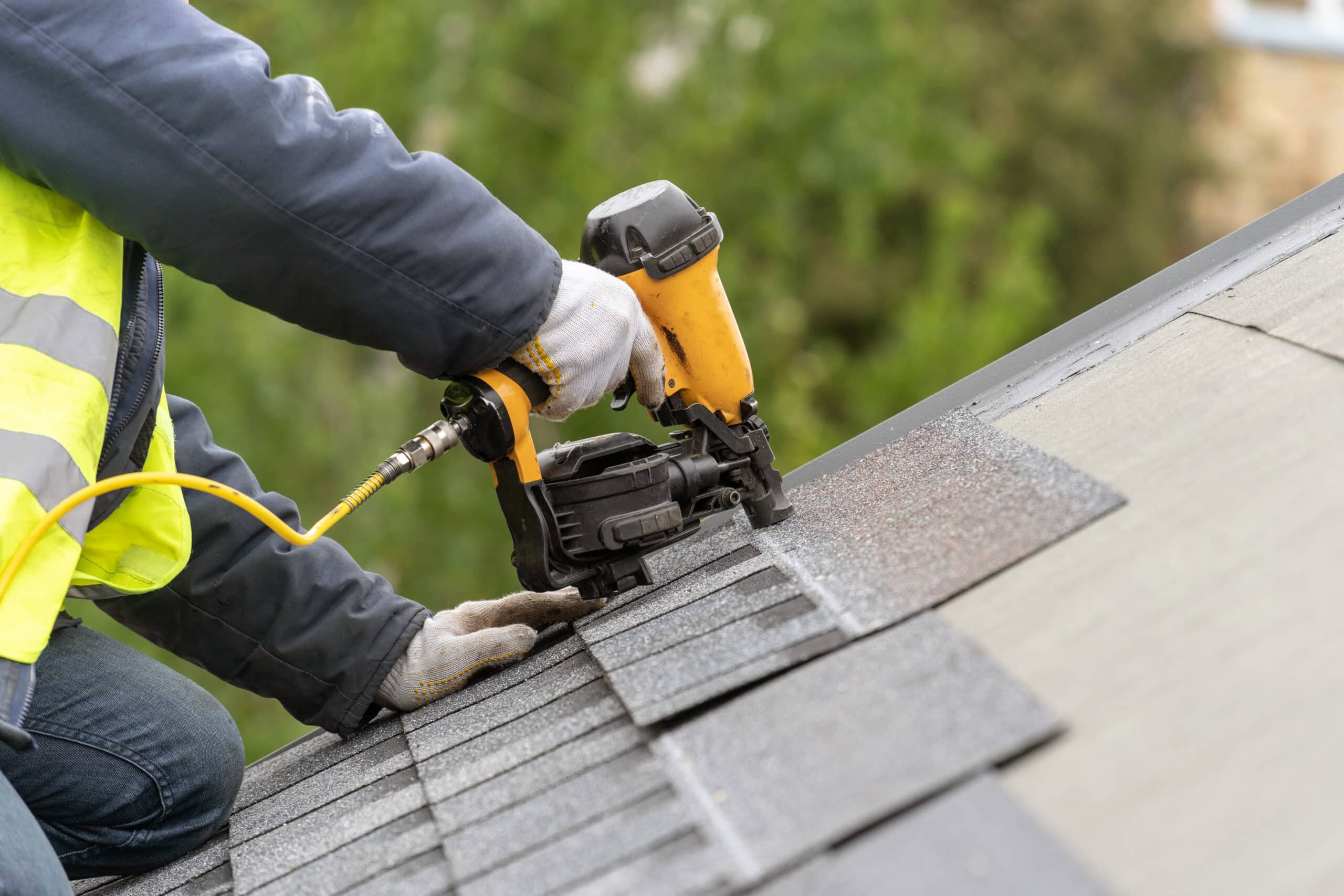 roofing contractor laying down shingles