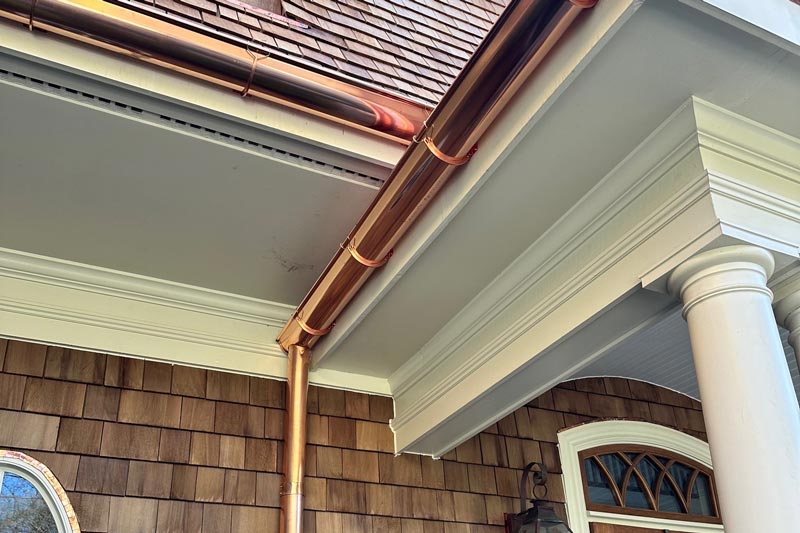 bronze gutter and downspout on the side of a home
