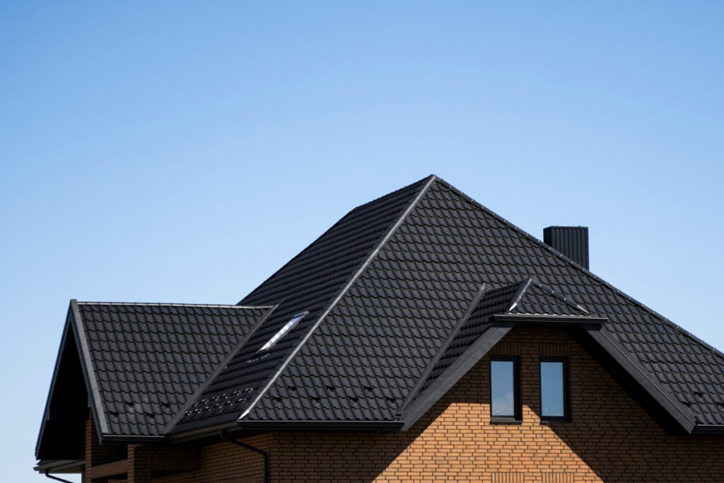 brown corrugated metal profile roof installed on a modern house with a attic windows