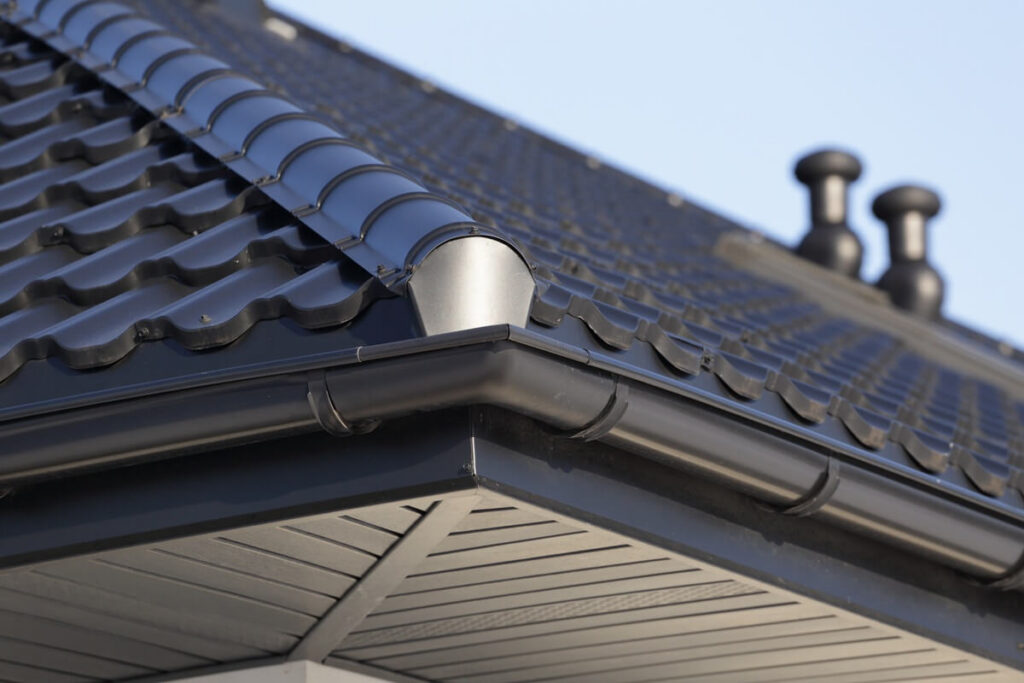 corner of the new modern house with gutter and ventilation chimneys