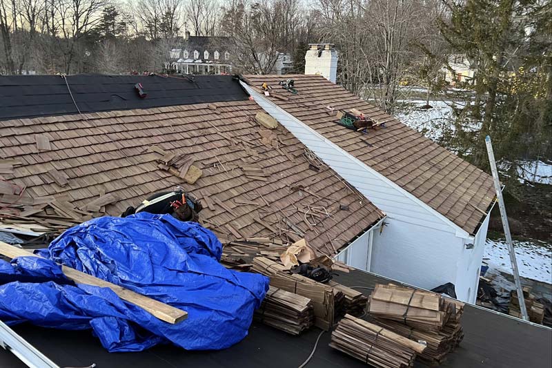 damaged roof being tarped and repaired by a Northern VA storm damage contractor