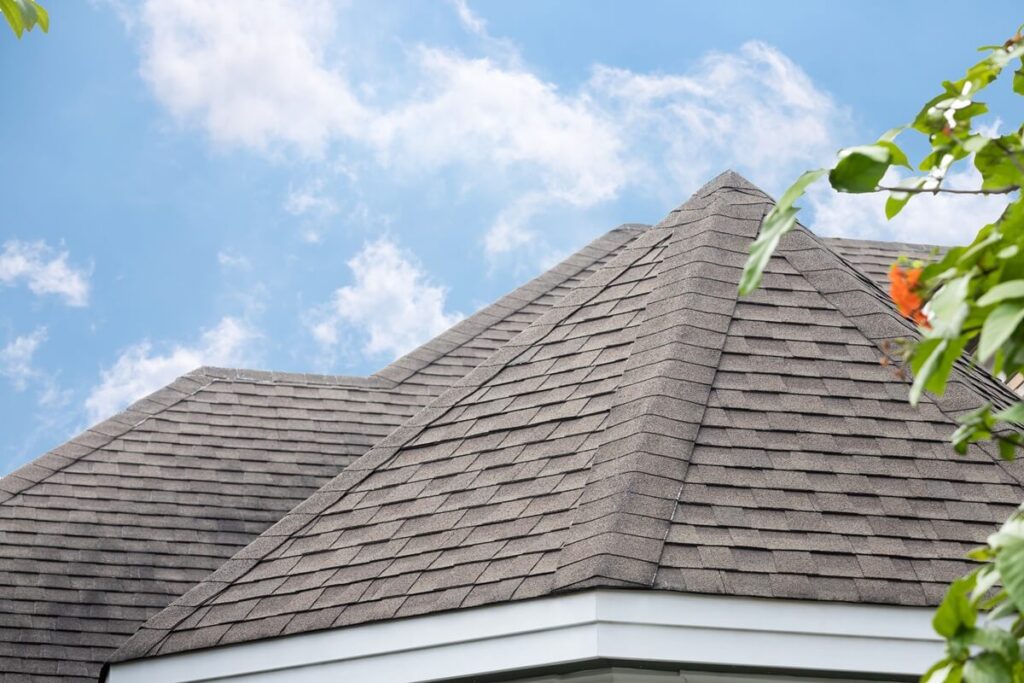 edge of roof shingles on top of the house, dark asphalt tiles on the roof background