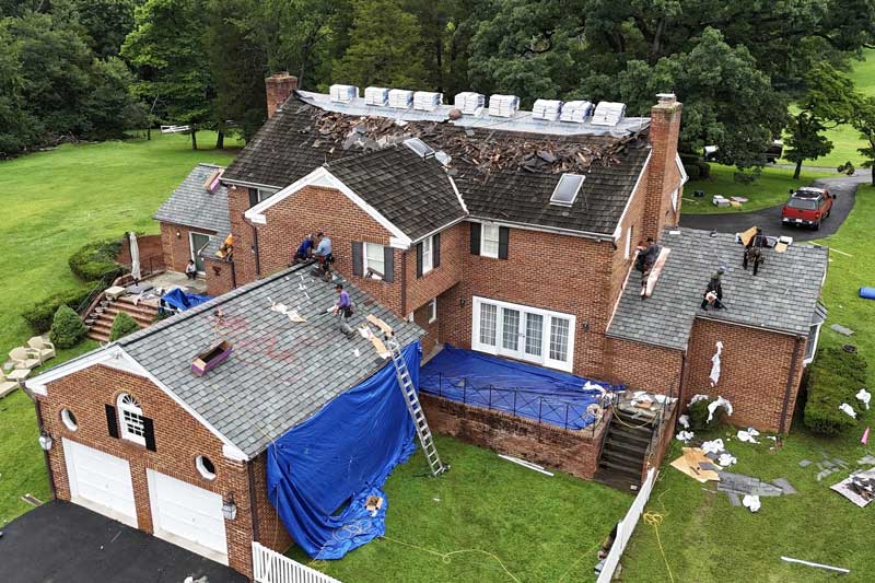 emergency roofing contractors at pure roofing working on a damaged home