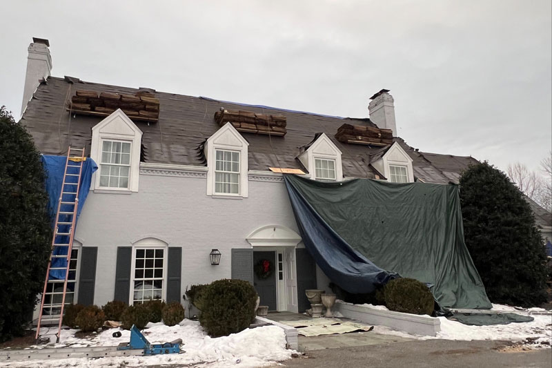 emergency roofing tarps being deployed after a storm