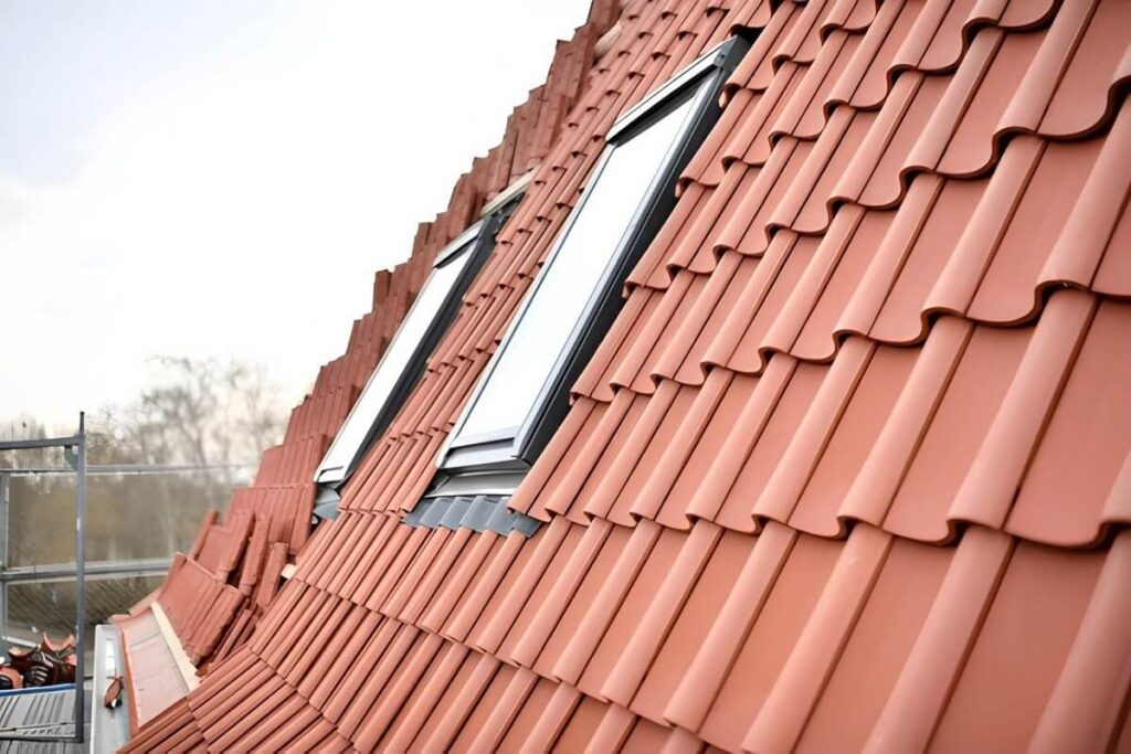german roof construction site with red roof tiles and skylight