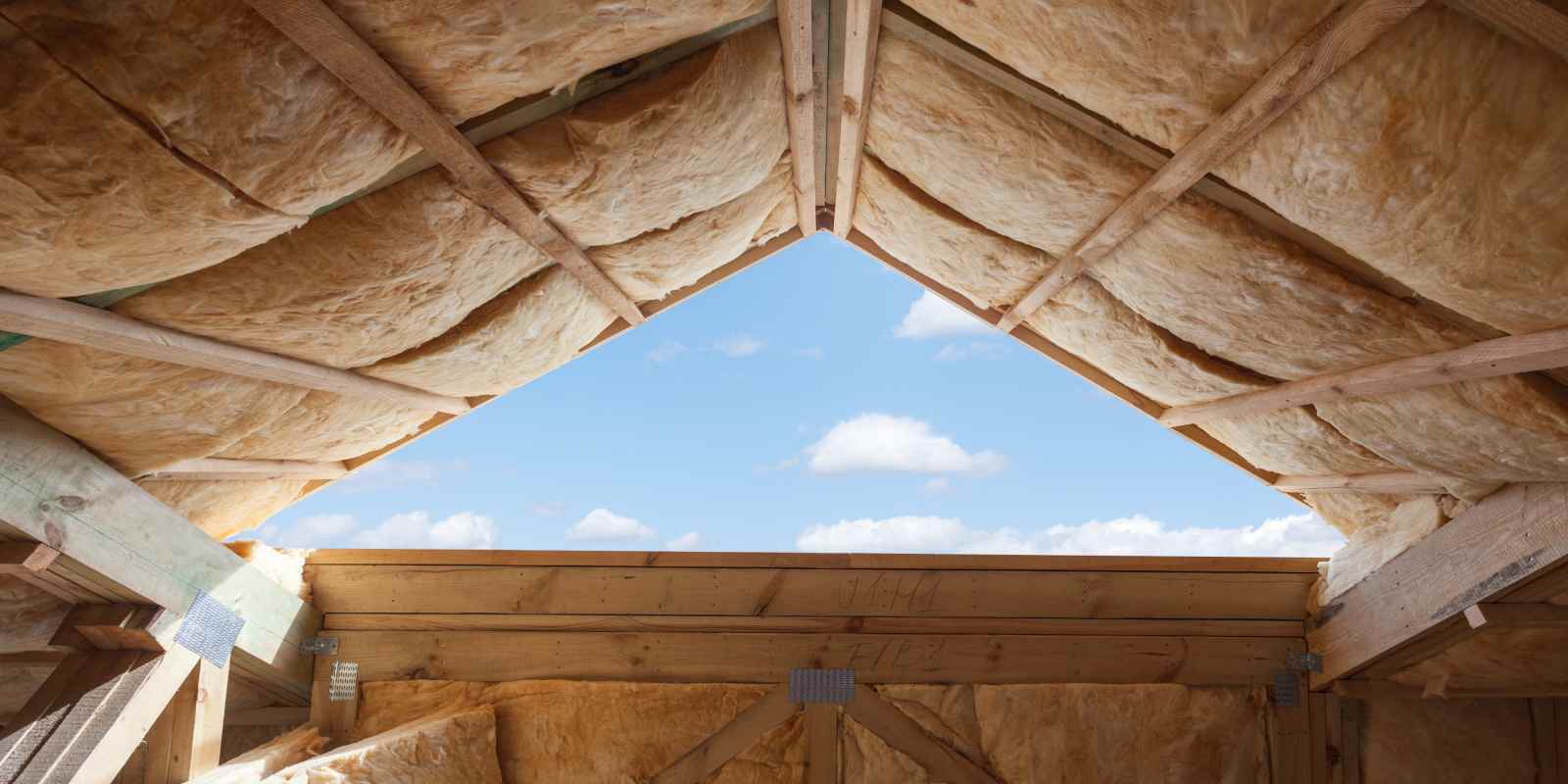 Fiberglass insulation was installed in the sloping ceiling of a new frame house.