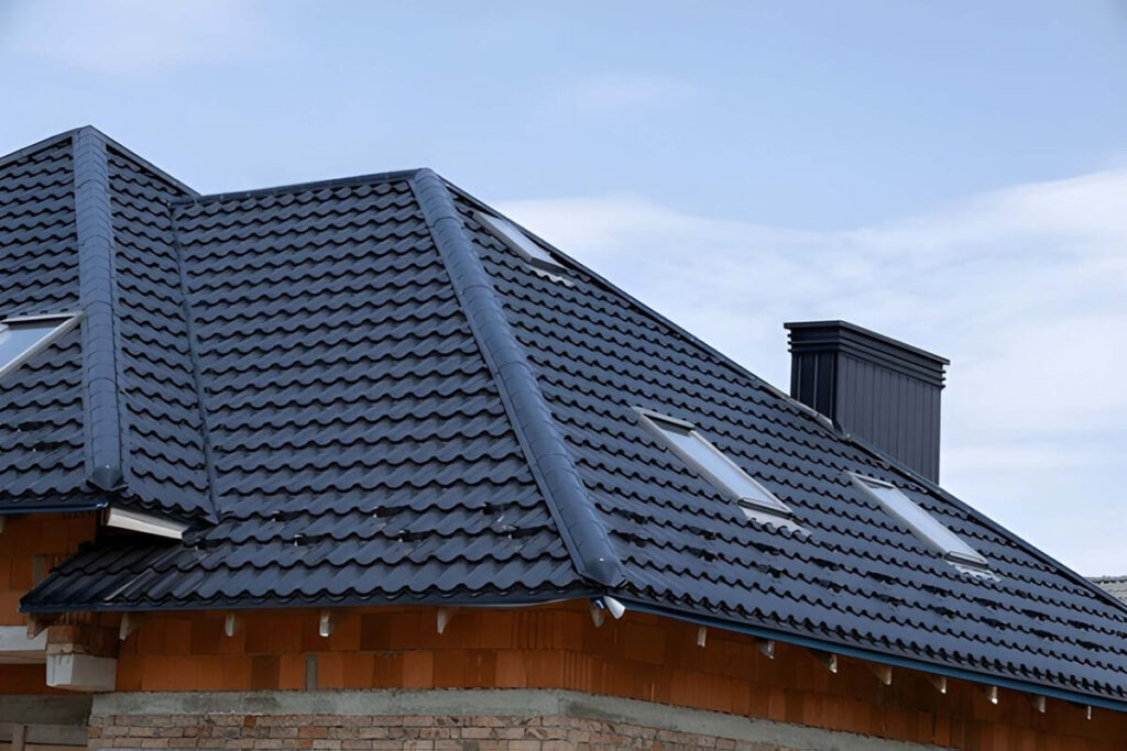 modern home features a newly installed black tile roof with skylights under a bright blue sky
