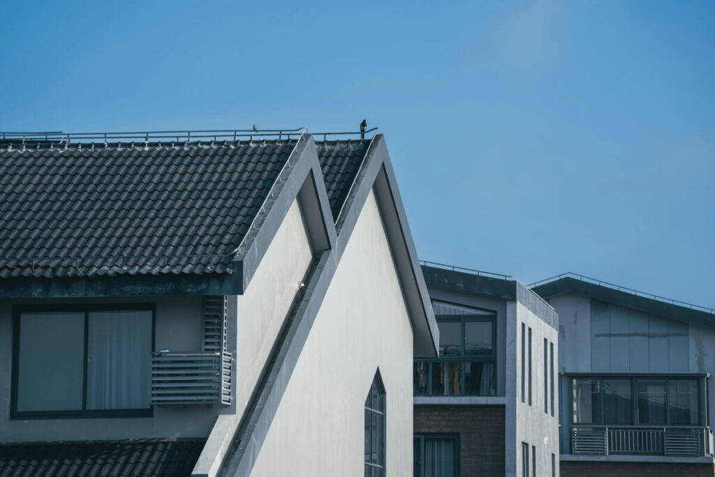 modern residential buildings with unique architectural rooftops under a clear blue sky