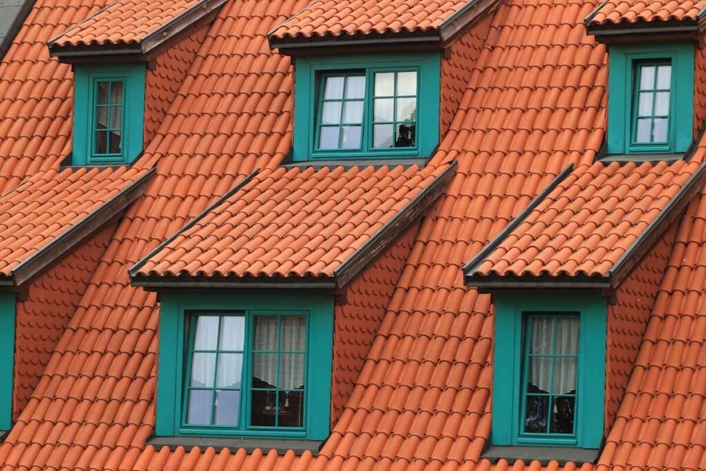 orange tiled roof with green framed dormer windows