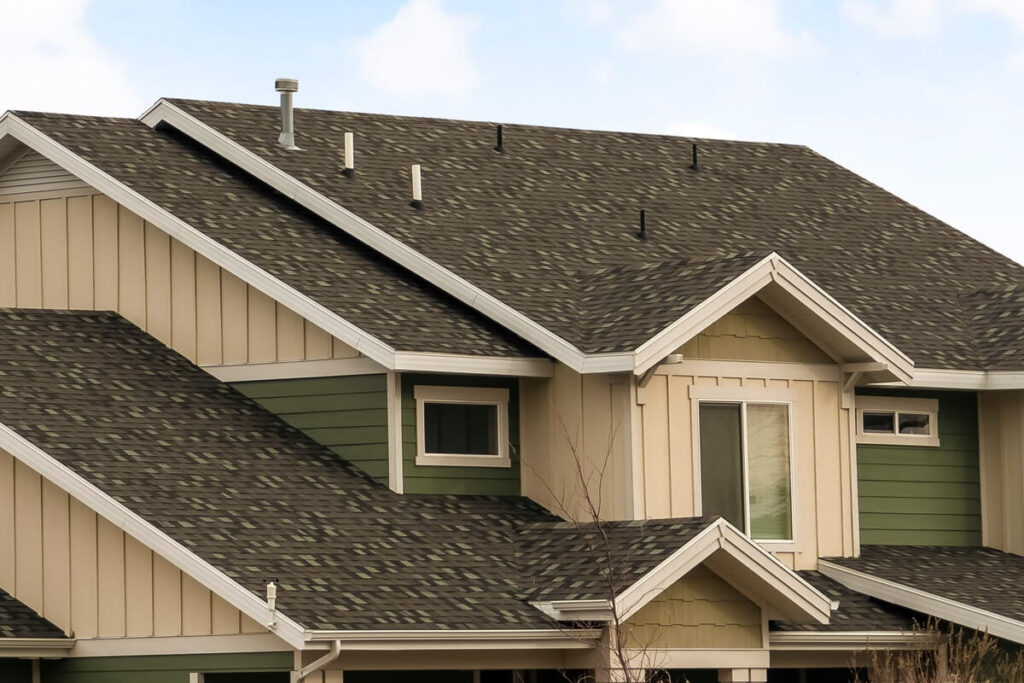 panorama frame house exterior with view of the dark pitched roof against a cloudy blue sky
