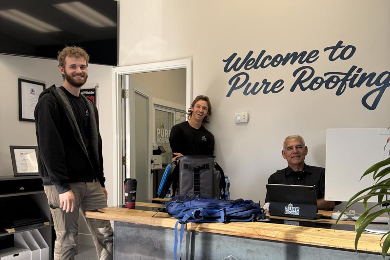 Pure Roofing team members smiling in the office