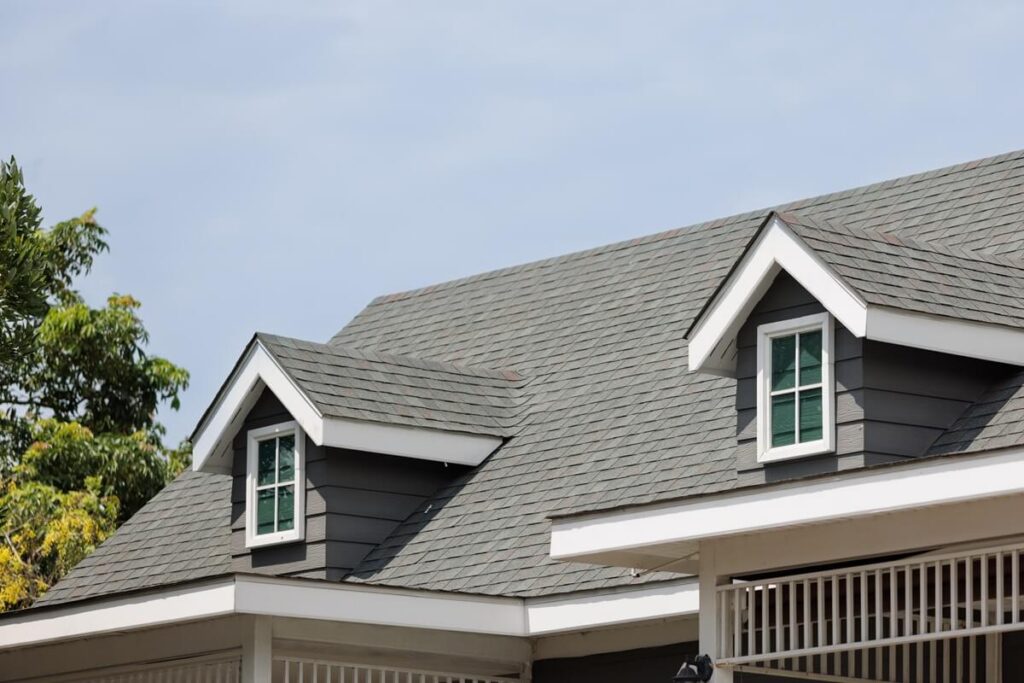 roof shingles with garret house on top of the house. dark asphalt tiles on the roof background on afternoon time