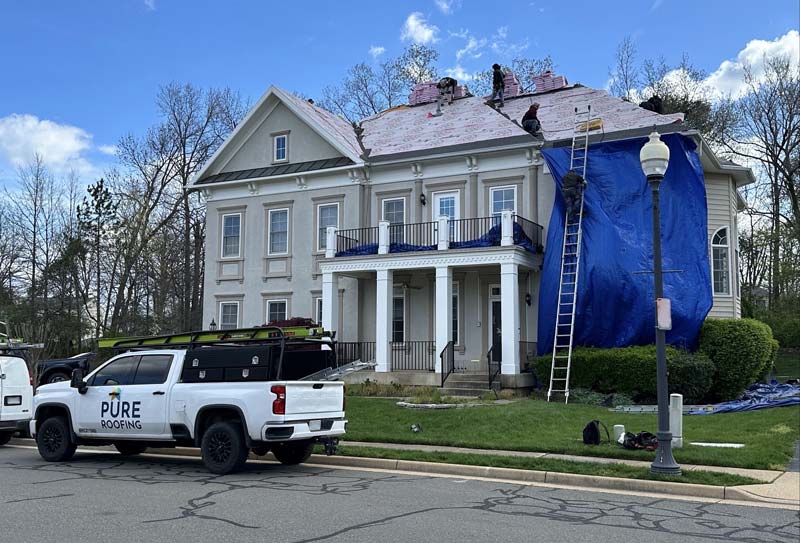 side of a home that has emergency tarp due to storm damage