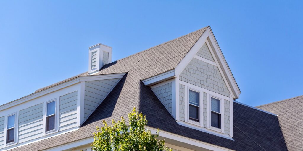 windows on the sloped shingle roof of a newly built house in Brighton