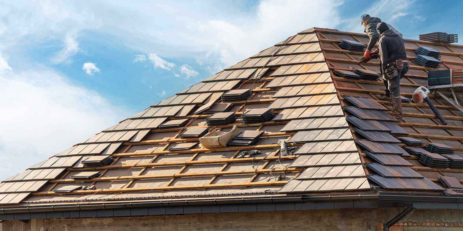 builder working on rooftop of house on construction site