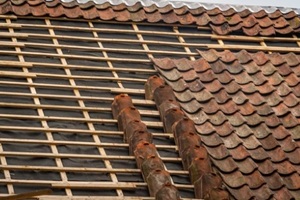 clay roof tile repair and replacement on old house during roof renovation
