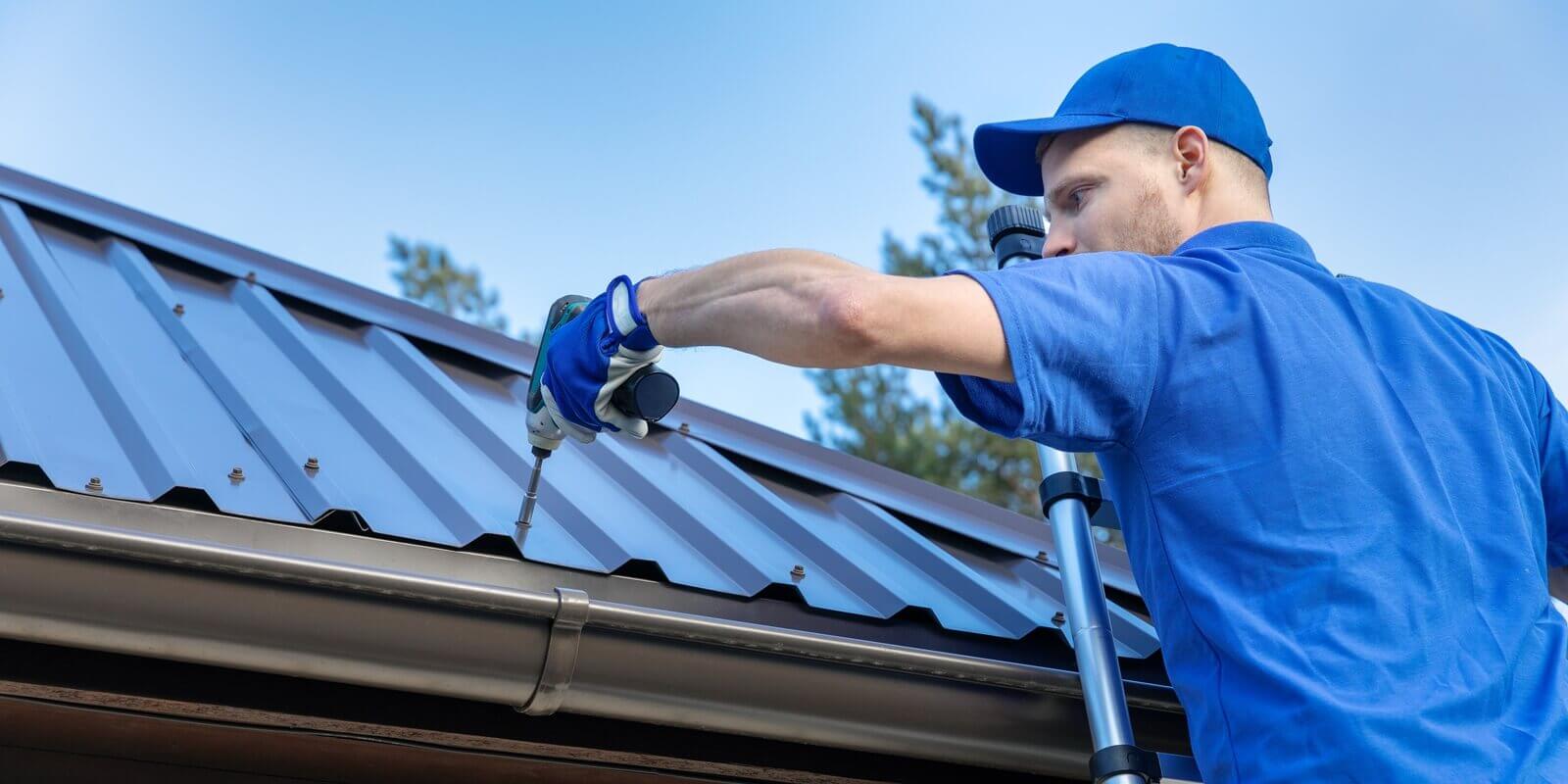 metal roofing - roofer working on the house roof